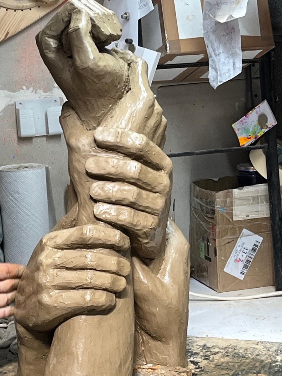 Detail of the clay model showing the hands and shofar taking shape